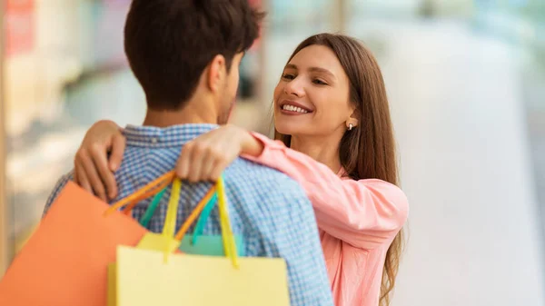 Amantes cónyuges abrazando hacer compras juntos en el centro comercial en interiores, Panorama —  Fotos de Stock