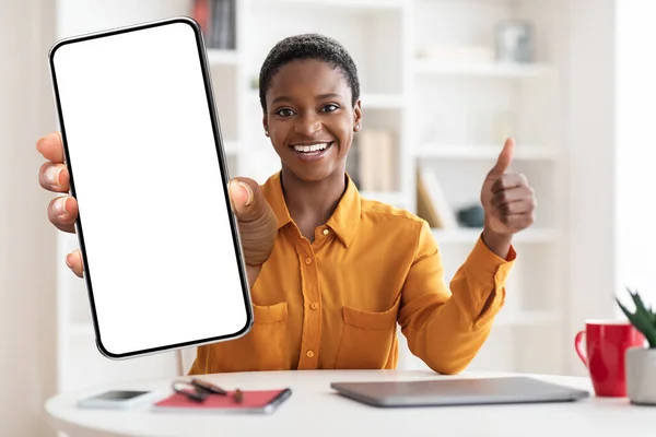 Smiling black woman showing smartphone with empty screen, mockup — Foto Stock