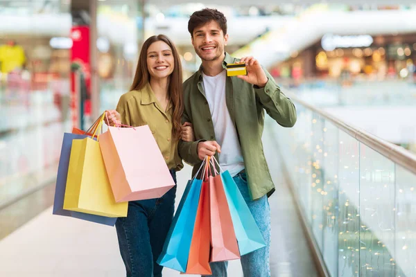 Cheerful Couple Showing Credit Card Shopping In Modern Hypermarket — Fotografia de Stock
