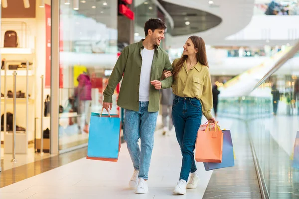 Casal alegre compras andando transportando sacos de Shopper no shopping — Fotografia de Stock