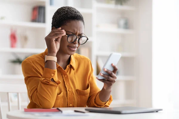 Σύγχυση μαύρη γυναίκα κοιτάζοντας οθόνη smartphone, αγγίζοντας τα γυαλιά — Φωτογραφία Αρχείου