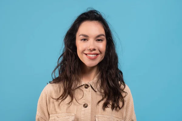 Smiling young european brunette woman in casual looking at camera isolated on blue background — 스톡 사진