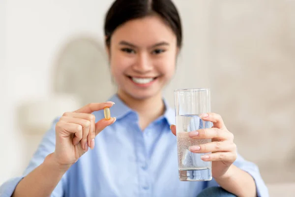Wanita asia ceria memegang segelas air dan pil — Stok Foto