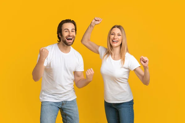 Satisfait jeune mari caucasien et femme blonde en t-shirt blanc se réjouissent de la victoire, beaucoup — Photo