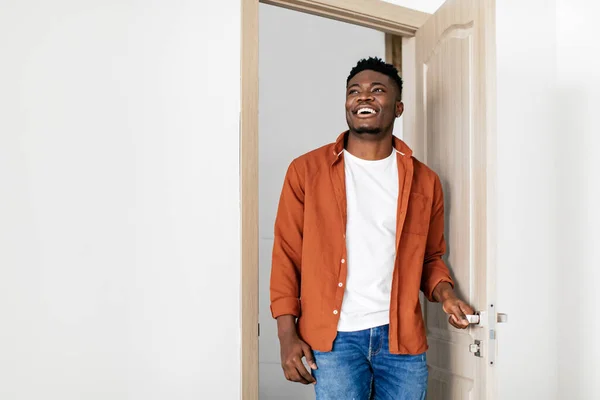 陽気な黒人男が新しい家に入るドアを開く — ストック写真