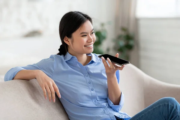 Primer plano de alegre mujer asiática sosteniendo smartphone, grabación de mensaje de voz — Foto de Stock