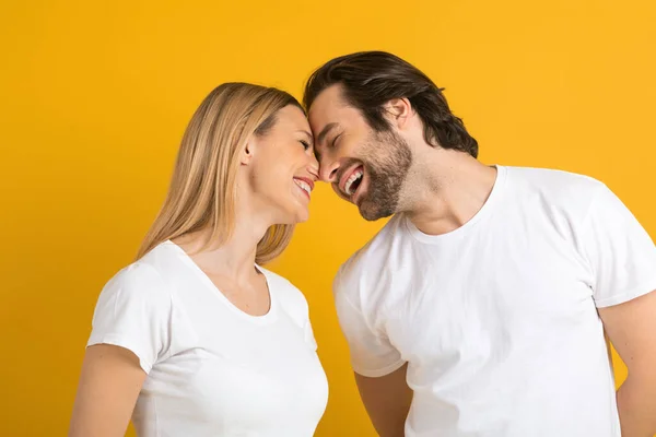 Cheerful happy young european male and female in white t-shirts have fun and enjoy tender moment — стокове фото