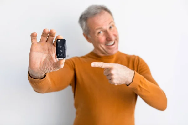 Izgalmas Man Holding Car Key és mutató, fehér háttér — Stock Fotó
