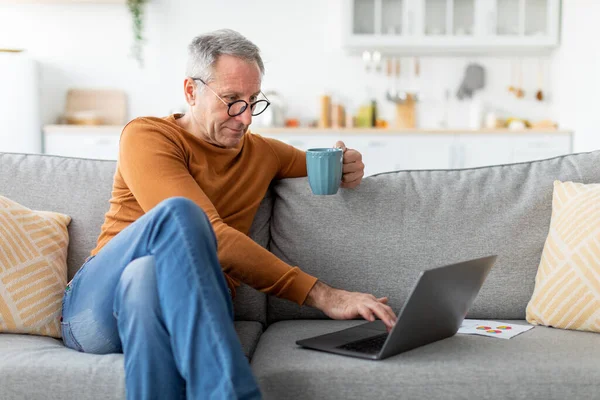 Mature man working on computer, drinking coffee — Foto de Stock