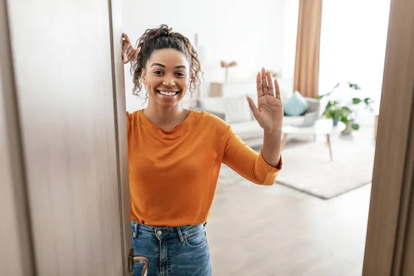 Cheerful Black Female Opening Door Of House Waving Hand Indoor — Foto Stock