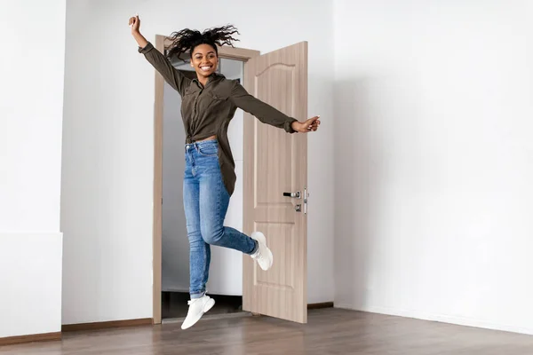 Joyful Black Lady Jumping Near Door Celebrating Moving New Home — Foto Stock