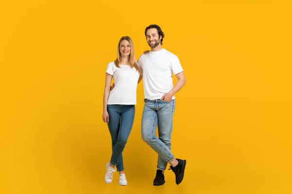 Smiling young european man with beard and woman stand, look at camera, isolated on yellow background — 图库照片