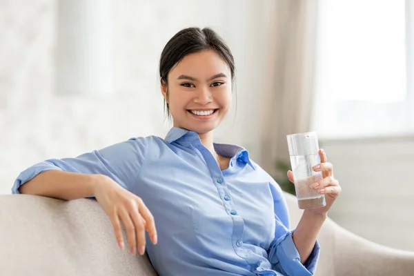 Portrait of cheerful asian woman holding glass of water — Stock Photo, Image