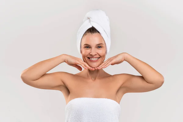 Beauty Care. Happy beautiful woman wrapped in towel touching chin with hands — 图库照片