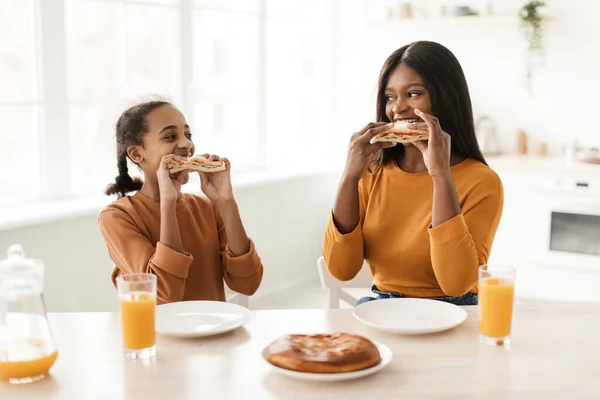African Mom And Daughter Eating Sandwiches Having Lunch In Kitchen