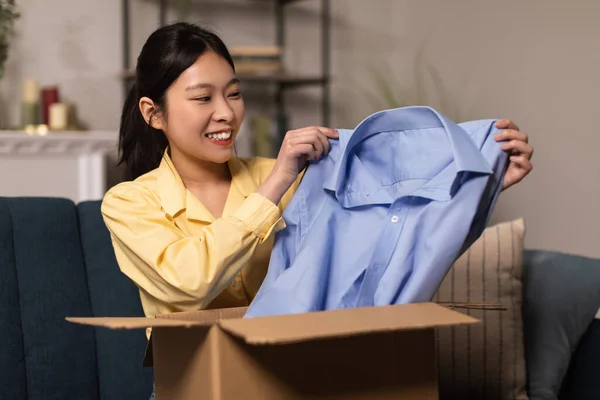 Happy asijské žena vybalování balíček po on-line nakupování — Stock fotografie