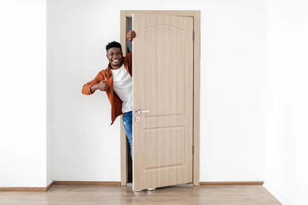Afro-Amerikaanse man die duimen opzuigt en de deur van het huis opent — Stockfoto