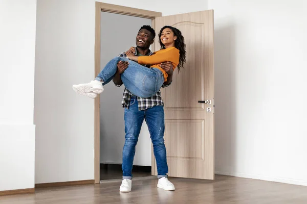 African American Man Carrying Wife Entering Room Moving New Home — Foto de Stock