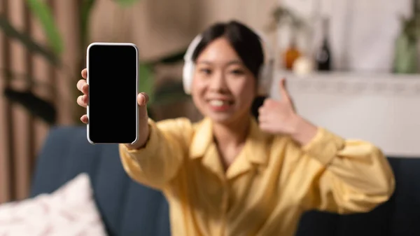 Sonriente mujer asiática mostrando pantalla de teléfono en blanco y como, maqueta — Foto de Stock