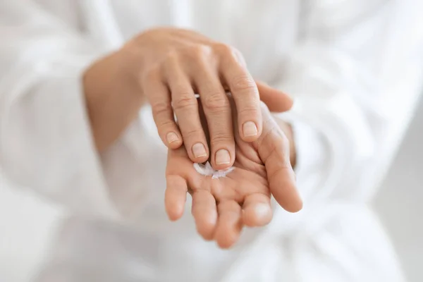 Cultivado de señora adulta usando crema de manos después de la ducha —  Fotos de Stock