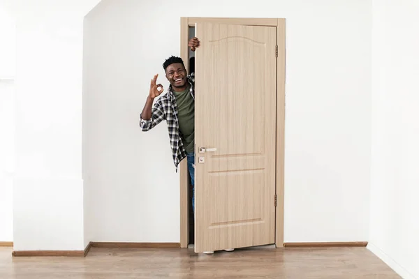 Afrikaanse Guy Gesturing OK staande in geopende deur thuis — Stockfoto