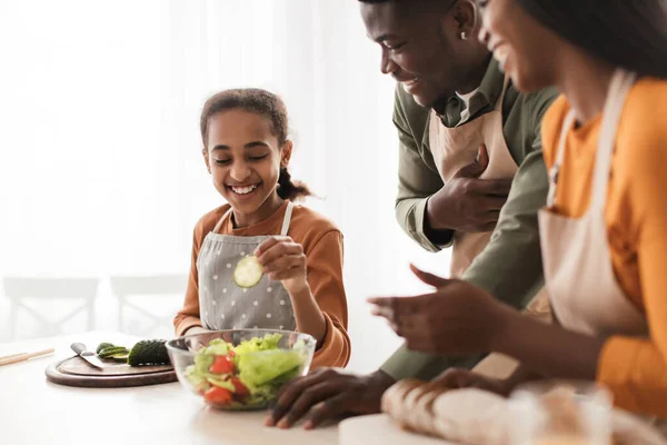 Alegre familia negra haciendo ensalada cocinar en la cocina, enfoque selectivo — Foto de Stock