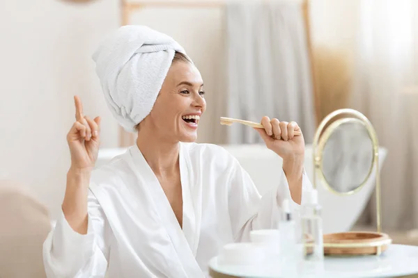 Happy adult woman brushing her teeth and singing —  Fotos de Stock