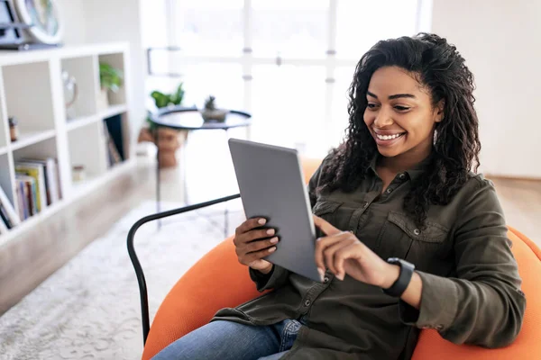 Portrait of smiling black woman using digital tablet at home — Stockfoto