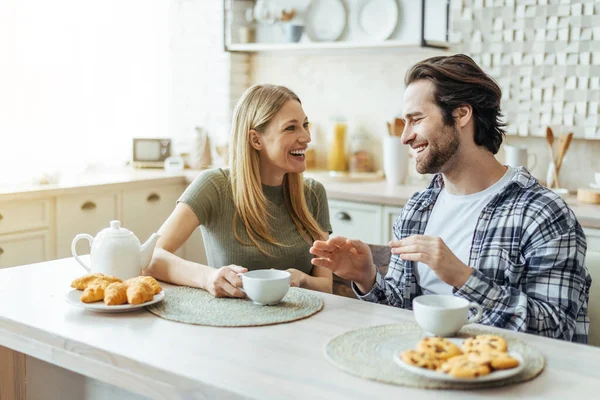 Glad happy european millennial wife blonde and man with stubble have breakfast together and talking — Stock fotografie