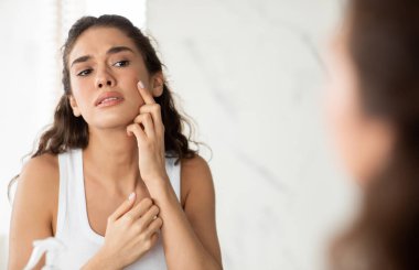 Modern tuvalette Depresyondaki Kadın Sivilceye Dokunuyor