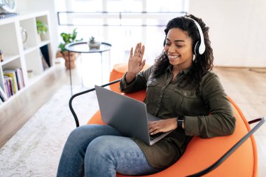 Black woman having video call using laptop and waving