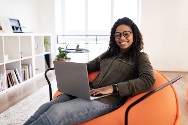 Portrait de femme noire souriante utilisant un ordinateur portable à la maison — Photo
