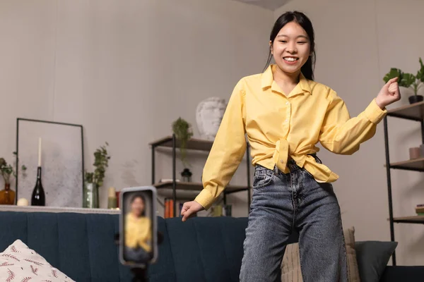 Glada asiatiska kvinna dansar på kameran filma video på telefon — Stockfoto