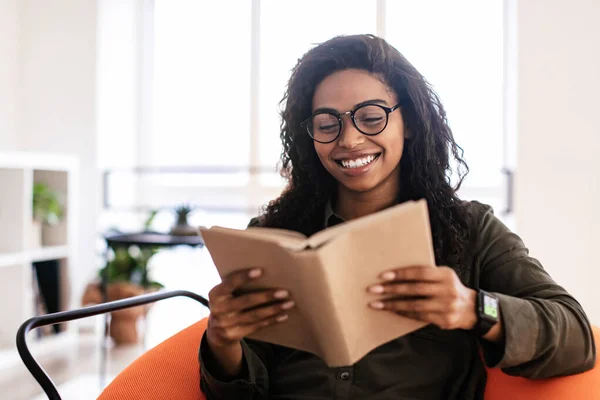 Smiling black woman in glasses reading book — Foto de Stock