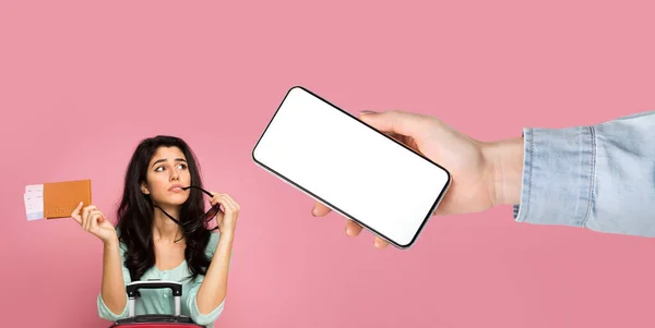 Dreamy lady looking at big empty smartphone screen holding tickets — Stock Photo, Image