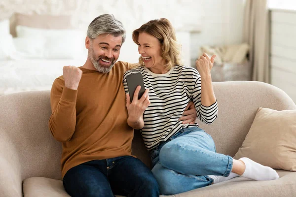 Mutlu Orta Çağ Çiftleri Evde Akıllı Telefon Çalkalama Yumrukları Kullanıyor — Stok fotoğraf