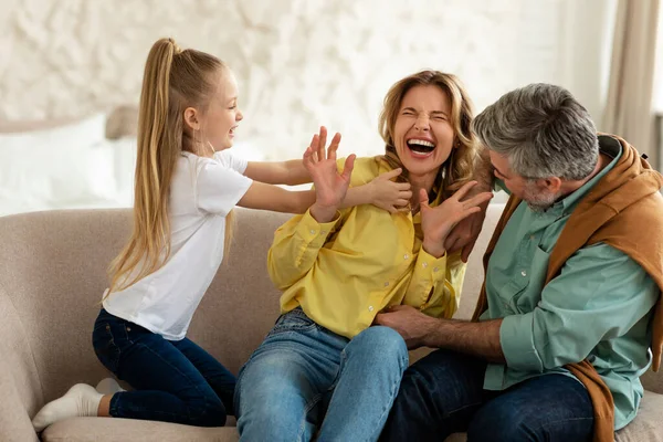 Glada familj av tre ha kul Tickling varandra inomhus — Stockfoto