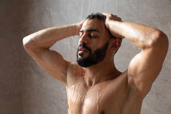 Красивый молодой арабский мужчина-модель принимает горячий душ — стоковое фото