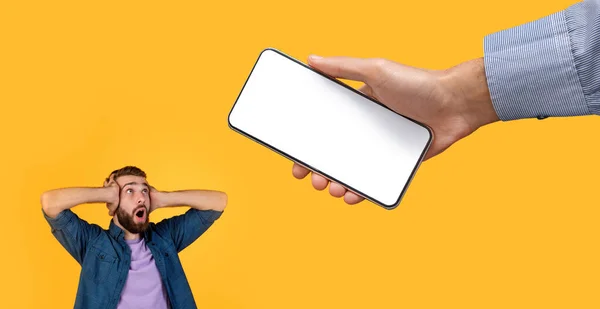 Překvapený chlap chytit hlavu při pohledu na bílou prázdnou obrazovku smartphone — Stock fotografie