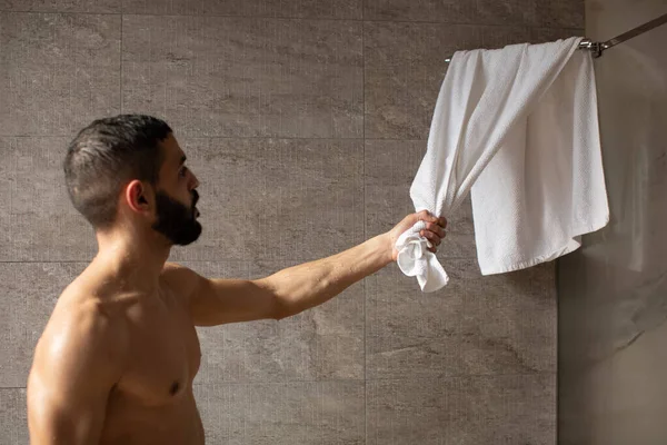 Bonito jovem árabe masculino agarrar toalha após o chuveiro — Fotografia de Stock