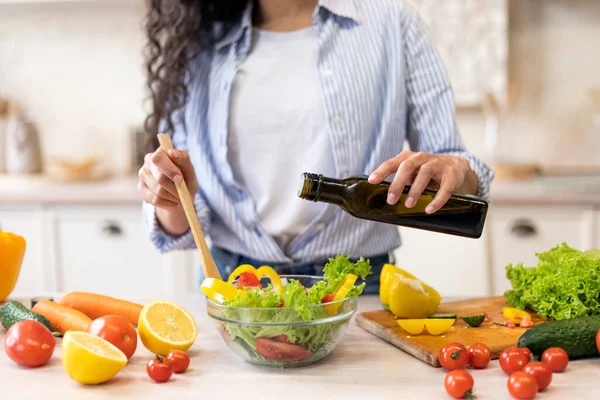 Lady cocinando ensalada de verduras frescas, añadiendo aceite de oliva y condimento al bowl, disfrutando comiendo comida vegetariana saludable — Foto de Stock