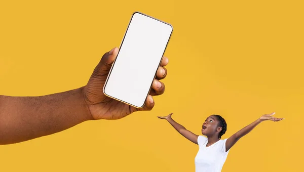 Überraschte schwarze Dame blickt auf großen weißen leeren Smartphone-Bildschirm — Stockfoto