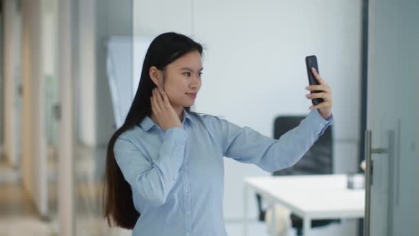 Joven positivo asiático señora haciendo selfie en smartphone, posando y sonriendo a dispositivo, enviando golpe beso — Vídeos de Stock