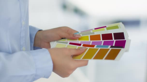 Крупный план неузнаваемая женщина дизайнер выбирая цвет для проекта, руки смешивая цветные образцы в офисе — стоковое видео
