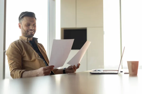 Радісний бізнесмен читає документи успіху на роботі в офісі — стокове фото
