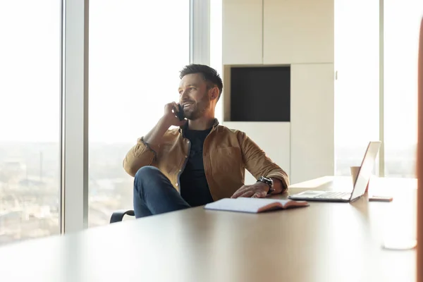 Empresário bem sucedido conversando no telefone sentado no local de trabalho no escritório — Fotografia de Stock