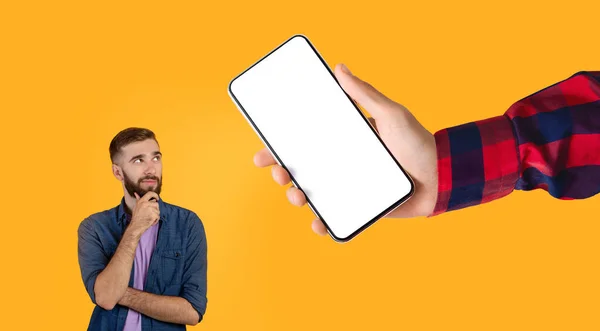 Aggressiver Typ mit Blick auf großen weißen, leeren Smartphone-Bildschirm — Stockfoto