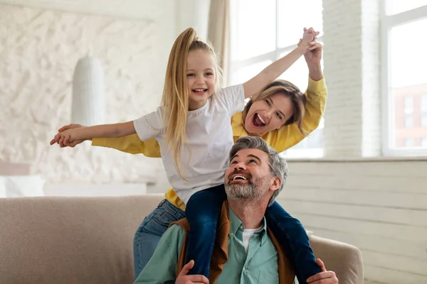 Vidám szülők és lánya szórakozás kötődés játszik otthon — Stock Fotó