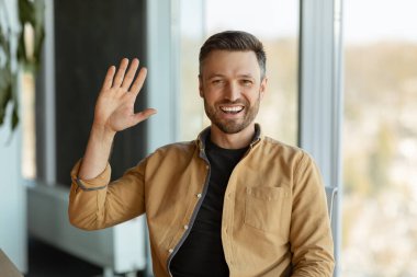 Neşeli İşadamı Ofiste oturan Kameraya Gülümsüyor