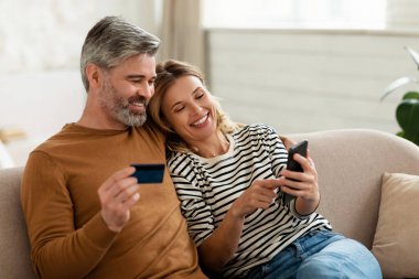 Karı-koca, telefon ve kredi kartı kullanarak alışveriş yapıyor.